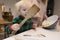 A toddler helping to bake a cake holding a large spatula.