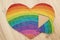 toddler inserting piece of heart shape rainbow puzzle.