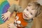 toddler inserting piece of heart shape rainbow puzzle.