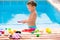 Toddler kid girl playing food toys in swimming pool