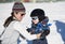 Toddler Learns to Ski with Mom. Dressed Safely with Helmet