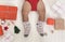 Toddler legs in knitted winter socks with Xmas gifts and decorations