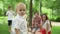 Toddler looking at camera with family. Children blowing soap bubbles in forest