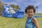 A toddler looks at the camera with a confused look while the bounce house inflates