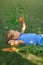 Toddler is lying on grass and carelessly nibbling fresh carrot