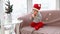 Toddler in a new year\'s costume santa sits at home by the window and eats