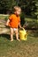 Toddler in orange shirt holding yellow pot