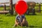 Toddler playing with red balloon. Children outdoor activities.