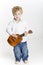 Toddler is playing on ukulele on white