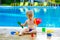 Toddler by the pool with toy bucket set