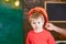 Toddler in protective hard hat, helmet at home in workshop. Carefully protect kid with helmet. Protection and safety