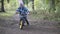 A toddler is riding a downhill from a small forest slide