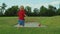 Toddler running on green grass. Blonde child playing in summer park