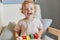 Toddler\\\'s imaginative play. Montessori learning tools. Laughing little blonde baby girl palying with wooden sorter toys at
