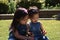 Toddler sisters playing with flowers outside