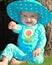 Toddler sitting on grass in a polkadot outfit