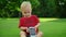 Toddler sitting in green meadow with phone. Cute child holding cellphone