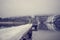 Toddler standing at the end of a snow covered pier on a lake