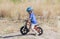 Toddler on a Strider Bike at a Dirt Track Wearing Helmet