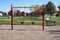 Toddler swings in a community playground with colorful posts and a wood chip ground