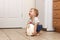 Toddler trying to lift up gallon of milk. copy space