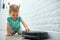 The toddler uses a robot vacuum cleaner to clean the floor of the apartment