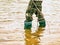 Toddler wearing rain boots standing in mudy puddle