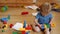 Toddlers build a tower in kindergarten. Child playing with colorful toys. Funny curly baby boy with educational toy