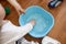 Toddlers hands in a blue basin on the floor