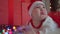 a todler girl in a santa hat plays with a gerland. The child is crying about Christmas gifts. A funny cute video with a