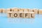 TOEFL - text of on wooden cubes, reflected from the bright blue surface
