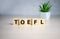 TOEFL - words from wooden blocks with letters, The Test of English as a Foreign Language, TOEFL concept, white background