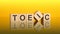 TOEIC - text of on wooden cubes, reflected from the bright yellow surface