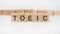 TOEIC word, text, written on wooden cubes, building blocks, over white background