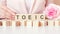 TOEIC - words from wooden blocks with letters, Test of English for International Communication, exam concept, pink