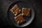 Toffee Bars On Black Matte Plate. Generative AI