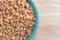 Toffee bits in a green bowl on a wood table