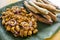 Tofu in peanut garlic sauce and Dynamite lumpia placed on a tray lined with banana leaves.