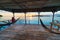 Togean Islands Sunrise, Togian Islands travel destination, Sulawesi, Indonesia. Woman looking at view on hammock, transparent turq