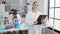 Together in science, man and woman scientists engrossed in medical research, writing on clipboard, using microscope at lab