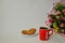 Togliatti, Samara region, Russia - November 26, 2019: Red NescafÃ© mug with coffee, oatmeal cookies and a bouquet of Alstroemeria.