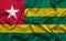 Togo national flag background with fabric texture. Flag of Togo waving in the wind. 3D illustration