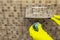 Toilet cubes cleaner in hand. A hand lowers a disinfectant cube into the water of a toilet bowl built into the wall