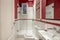 Toilet decorated in red and white tones with a shower cabin