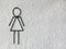 Toilet female signs on the abstract white rough cement wall background