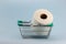 Toilet paper roll in shopping cart on blue background.Concept of hoarding, panic buying toilet paper. Covid-19 pandemic