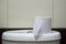 Toilet paper on white toilet tank closeup