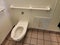 toilet and rusty heater in bathroom or restroom stall