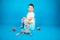 Toilet training concept. Toddler boy sits on a potty, blue background
