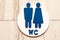 Toilet, wc icon, round wooden white and brown sign on restroom door in the hallway, restaurant, lobby. Concept sign of toilet room